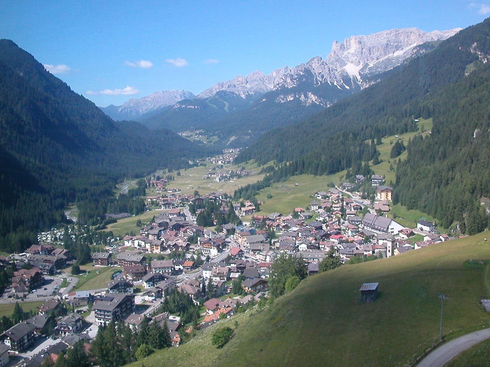 Campitello di Fassa nella valle, con il Latemar e il Catinaccio sullo sfondo