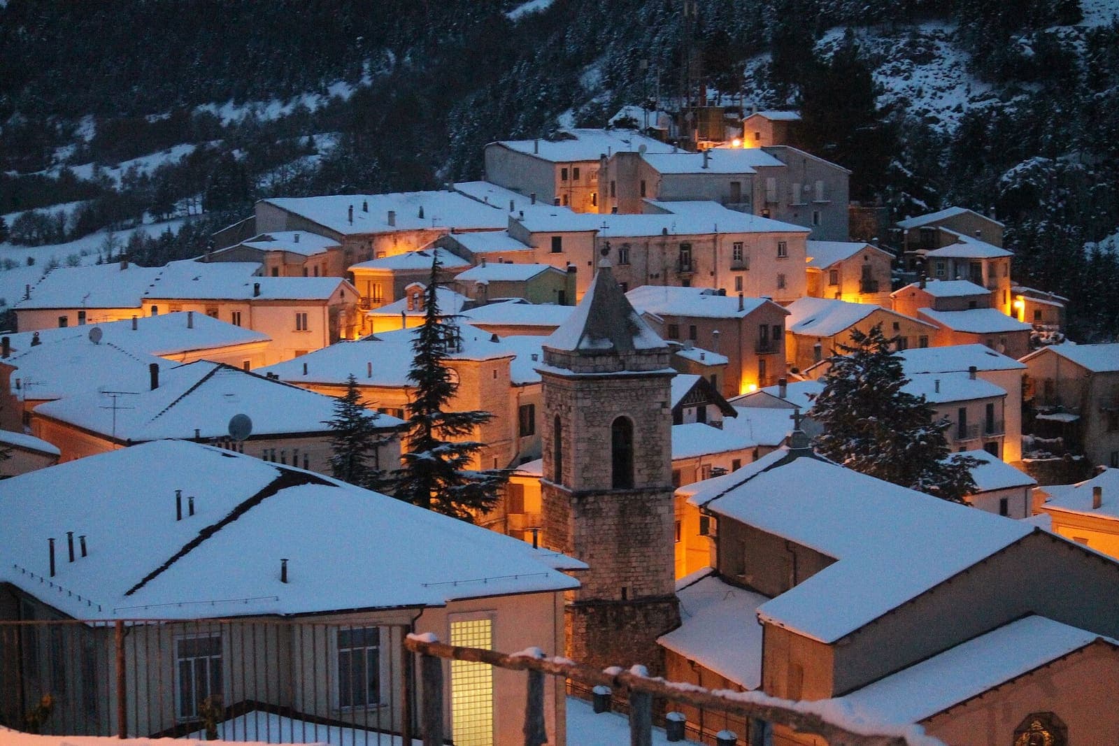 I tetti innevati di Carovilli al crepuscolo, con un campanile in pietra