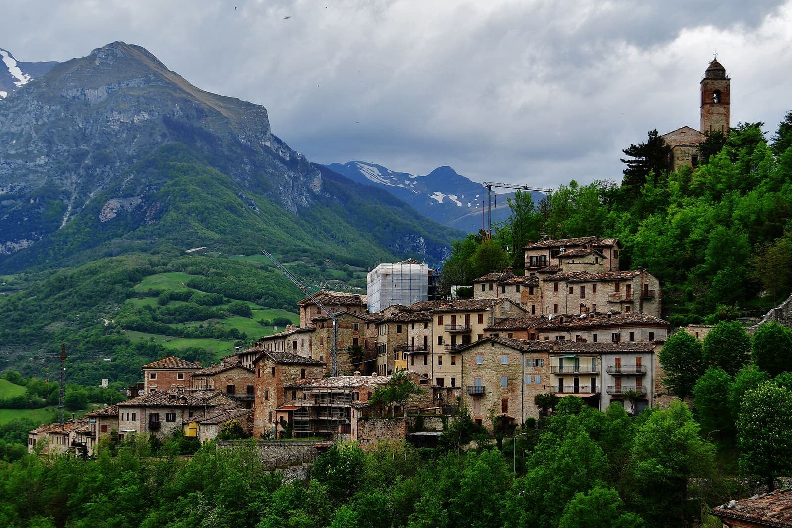 Montefortino con le case sul colle e i monti Sibillini sullo sfondo