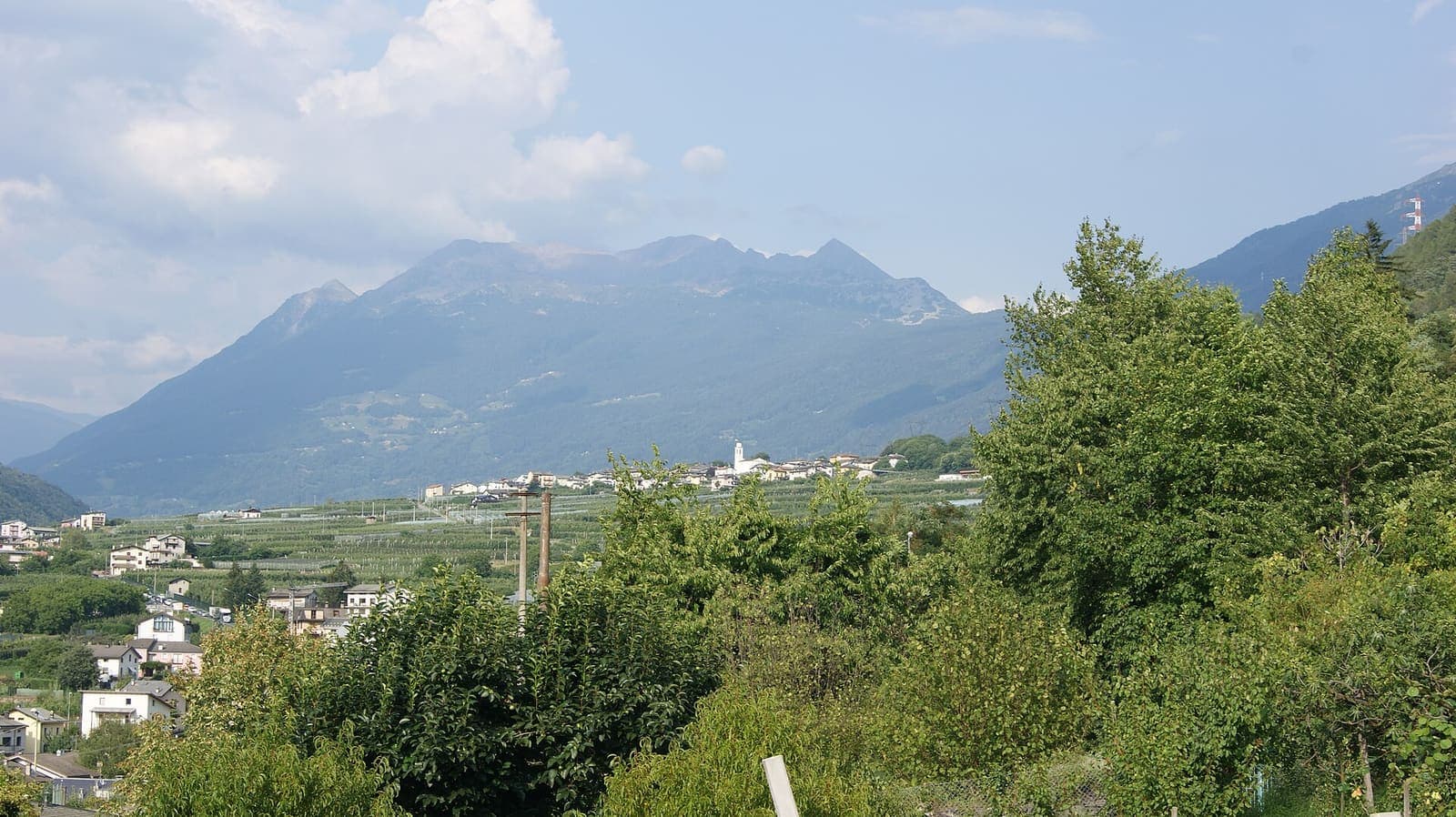 Villa di Tirano vista dal castello di Santa Maria di Tirano, con le case nella valle e le montagne