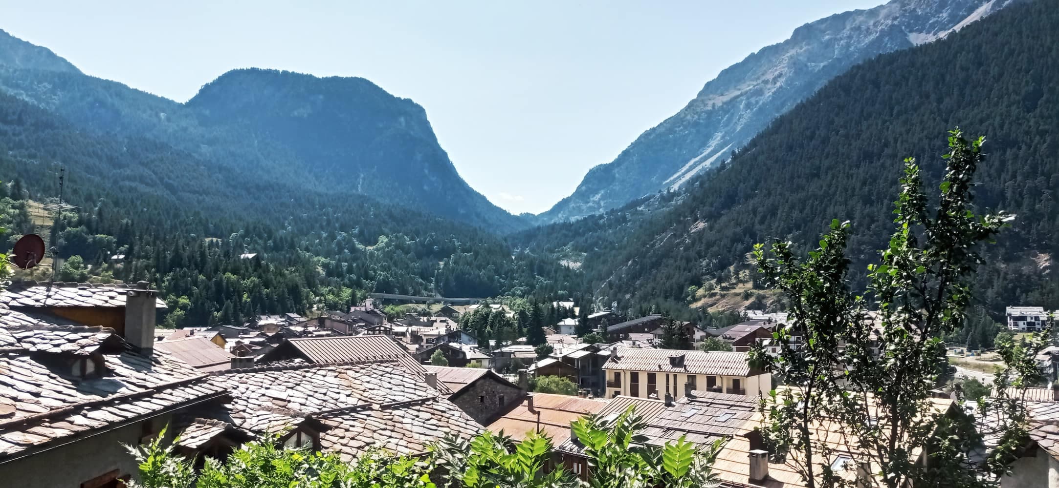 Cesana Torinese con i tetti delle case e le montagne verso il Monginevro