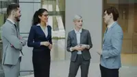 Professionisti in abito che conversano nella lobby di un ufficio moderno
