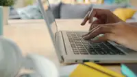 Mani che digitano sulla tastiera di un laptop mentre navigano sul web