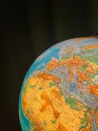 Primo piano di un mappamondo su fondo nero, dettaglio dei continenti