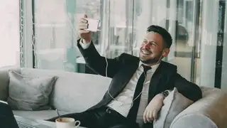Professionista sorridente in videochiamata con gli auricolari